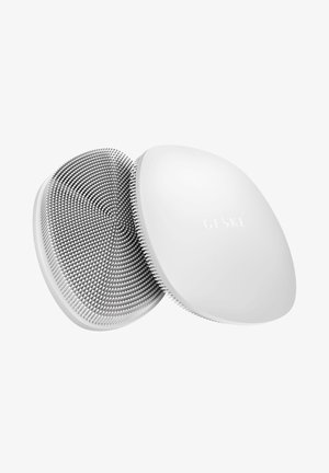 Ronde witte siliconen gezichtsreinigingsborstel met zachte haartjes en het merk "GESKE" op een gladde achterzijde.