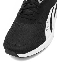 Melnas sporta kurpes ar struktūrētu mākslīgo audumu augšdaļu, baltas akcenti un pastiprināta purngala daļa. Iekļauj melnas šņores un mīkstu apkakli.