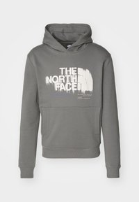 Sudadera gris de algodón con un gran estampado blanco de "THE NORTH FACE" en el frente, que cuenta con un bolsillo tipo canguro y puños y dobladillo acanalados.