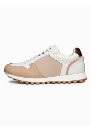 Hvid og beige lavskoet sneaker med tekstureret sidestykke, snørelukning foran, brun hælkappe og gummisål med mønster.