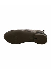 Schoen heeft een bruine rubberen zool met groeven voor grip; bovenkant heeft een gestructureerd ontwerp in tinten beige en bruin met decoratieve stiksels.