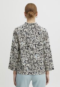 Witte en zwarte geblokte jas met blauwe accenten, met een ontspannen pasvorm, driekwart mouwen en een ronde hals.