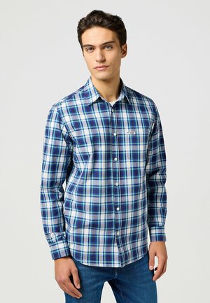 Camicia a quadri blu e bianchi con maniche lunghe, colletto button-down e taschino sul petto. Tessuto morbido con vestibilità regolare.