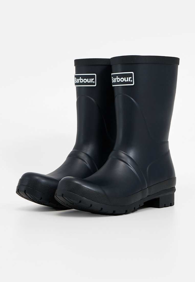 Schwarze Gummiregenstiefel mit glatter Oberfläche, Blockabsatz und Logo an der Vorderseite. Entworfen für wasserdichten Schutz und Haltbarkeit.