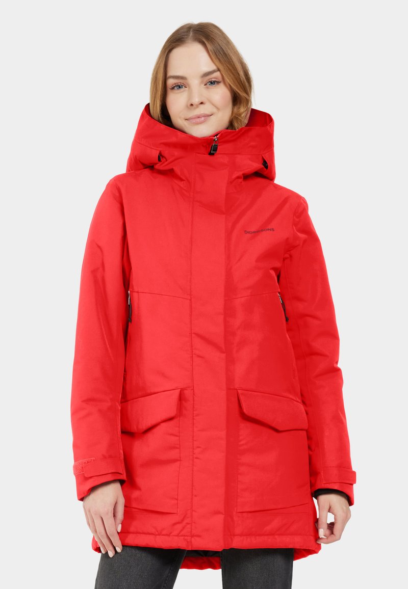 Röd isolerad parka med huva, med dragkedjestängning fram, sidofickor och rak fåll. Tillverkad av glansigt, slitstarkt tyg.