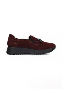 Scarpa slip-on in suede bordeaux scuro con suola nera spessa e fibbia decorativa nera sulla parte superiore, angolata per mostrare il lato esterno.