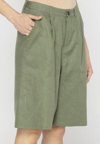 Krótke spodenki w kolorze khaki, wykonane z lekkiego materiału, wykonane w tapered designie, z dwoma bocznymi kieszeniami, zamek błyskawiczny i plastikowy guzik.