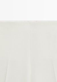 Tissu blanc drapé, texture lisse, légèrement translucide avec des plis doux. Aucun motif ni détail supplémentaire visible.