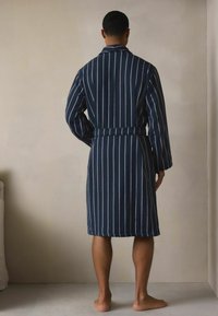 Tums zilās svītrains peldmētelis, izgatavots no mīksta auduma, ar garām piedurknēm, jostu viduklī un līdz ceļiem garumu. Ar vertikālām svītrām.