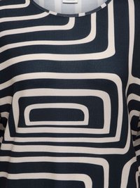 Tissu bleu marine avec un motif géométrique blanc de rectangles arrondis interconnectés sur un top en coton stretch.