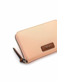 Peach-colored wallet with a smooth texture, a zip closure, and a brown leather accent. Features a logo on the front and a wrist strap.