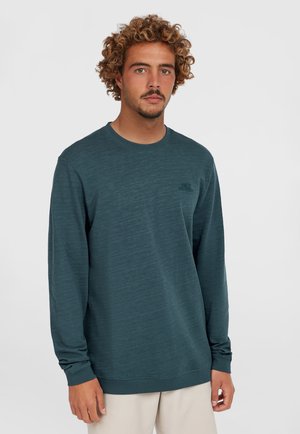 Dark teal long-sleeve sweatshirt in a textured fabric, featuring a crew neck, ribbed cuffs, and a small, embroidered logo on the chest.