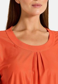 T-Shirt mit rundem Ausschnitt, mit gef pleateten Details, aus glattem Stoff, in leuchtend orange. Kurzärmlig und mit lockerer Passform.