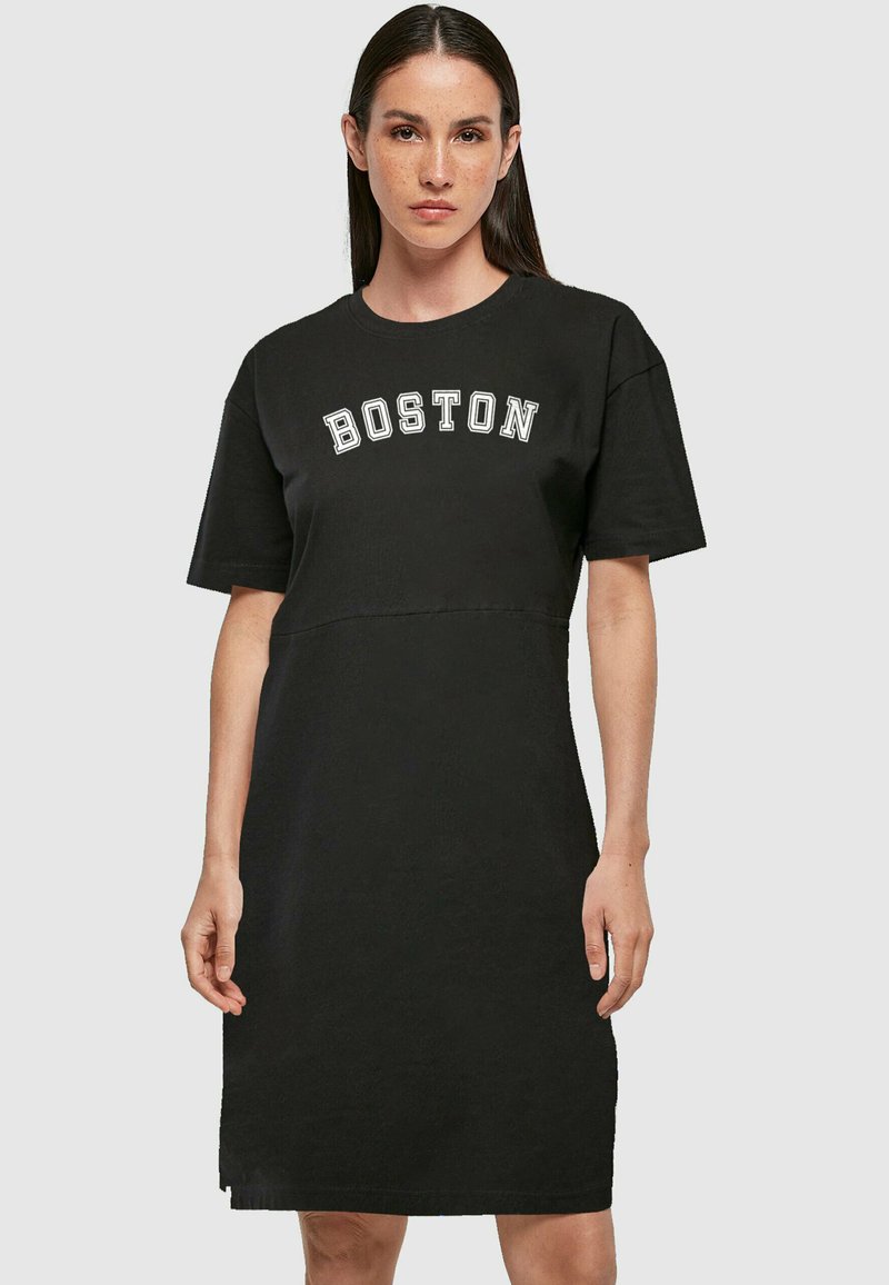 Fekete pólóruha rövid ujjakkal, fehér "BOSTON" felirattal a mellkasán, laza fazonnal, puha pamut anyagból készült.
