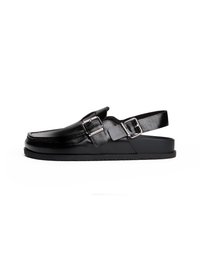 Scarpa slingback in pelle nera con punta arrotondata, caratterizzata da un accento con fibbia e suola piatta in gomma. Texture liscia, design minimalista.