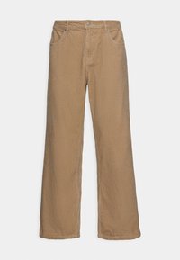 Pantalon large en velours côtelé marron avec une surface texturée, fermeture par bouton et cinq poches. Coupe ample avec une forme droite et décontractée.