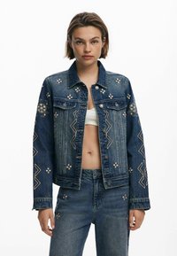 Jeansjacka med blommig broderi, figurnära design, mörkblå färg, silverdetaljer, med zigzagmönster på ärmar och kropp.
