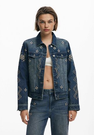 Giacca di jeans con ricami floreali, design aderente, colore blu scuro, hardware argentato, con motivi a zigzag sulle maniche e sul torso.
