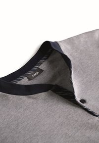 Camicia grigia con colletto e bottoni neri, dotata di una placca interna a righe e un'etichetta del marchio "cagi." all'interno del collo.