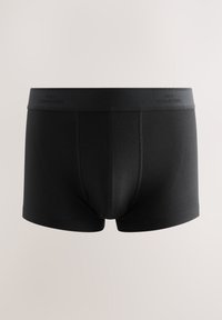 Boxers noirs pour homme avec une ceinture lisse étiquetée "Next Signature" et des coutures visibles pour le contour.