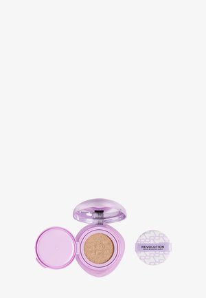 Lilla kompakt pudderfoundation etui åbnet med beige makeup svamp og separat rund påføringspude mærket "Revolution."