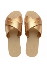 Infradito color oro con cinturini incrociati e suola testurizzata. Realizzate in materiale gommoso, con il logo Havaianas sul lato.