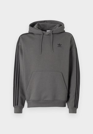 Grauer Kapuzenpullover mit Kängurutasche, schwarzem Adidas-Logo und schwarzen Drei-Streifen-Akzenten an den Ärmeln. Hergestellt aus weichem, strukturiertem Stoff.