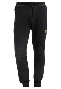 Black sweatpants made of soft fabric, featuring an elastic waistband with drawstring, and a small gold Nike logo on the left thigh.
