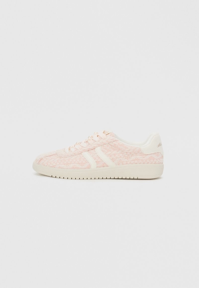 Adidași roz deschis cu superior din țesătură texturată, având accente și șireturi albe, o talpă din cauciuc plat și o marcă subtile pe călcâi.