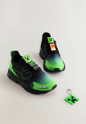 Grüne und schwarze Sneakers mit einem Farbverlaufsdesign, die Minecraft-Charms an den Schnürsenkeln und ein Schlüsselanhänger-Zubehör aufweisen.