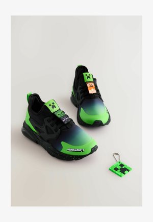 Zaļi un melni sporta apavi ar gradienta dizainu, piedāvā Minecraft varoņu piekariņus uz šņorēm un atslēgu piekariņu.