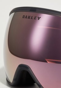 Skibriller med en mørkegrå ramme og store rosa linser. Har "Oakley"-logoen trykt i svart på linsen. Teksturerte skumlister.