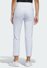 Φωτεινό γαλάζιο, εφαρμοστά παντελόνια με ομαλή υφή, μεσαίο ύψος μέσης και δύο πίσω τσέπες. Συνδυασμένα με λευκά αθλητικά παπούτσια με μαύρες λεπτομέρειες.