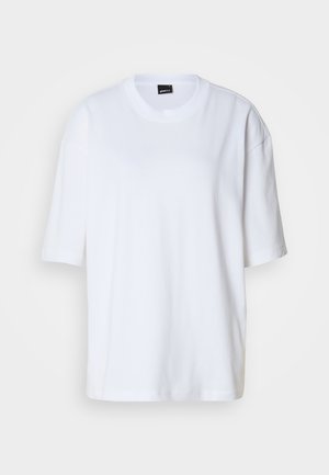 T-shirt bianco in cotone, maniche corte, scollatura rotonda, vestibilità comoda. Texture liscia, design minimalista, senza motivi o decorazioni.