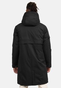 Juodas parkas su nusegamu gaubtu, ilgomis rankovėmis ir šoniniais kišenėmis. Lygus audinys su subtiliu blizgesiu, su nugaros ventiliacijos anga ir logotipo detale.