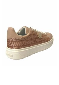 Sneaker rosa chiaro con tomaia testurizzata caratterizzata da cuori ripetuti e loghi del brand, lacci bianchi e una suola bianca spessa.