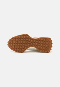 Rubber outsole with a textured surface, featuring round nubs. The design includes a slightly curved shape and a gum color.