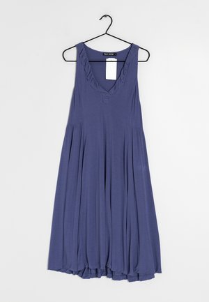 Fioletowa sukienka bez rękawów wykonana z miękkiego materiału, z głębokim dekoltem w kształcie litery V, falbankowym wykończeniem przy szyi i falującą, marszczoną spódnicą przy dole.