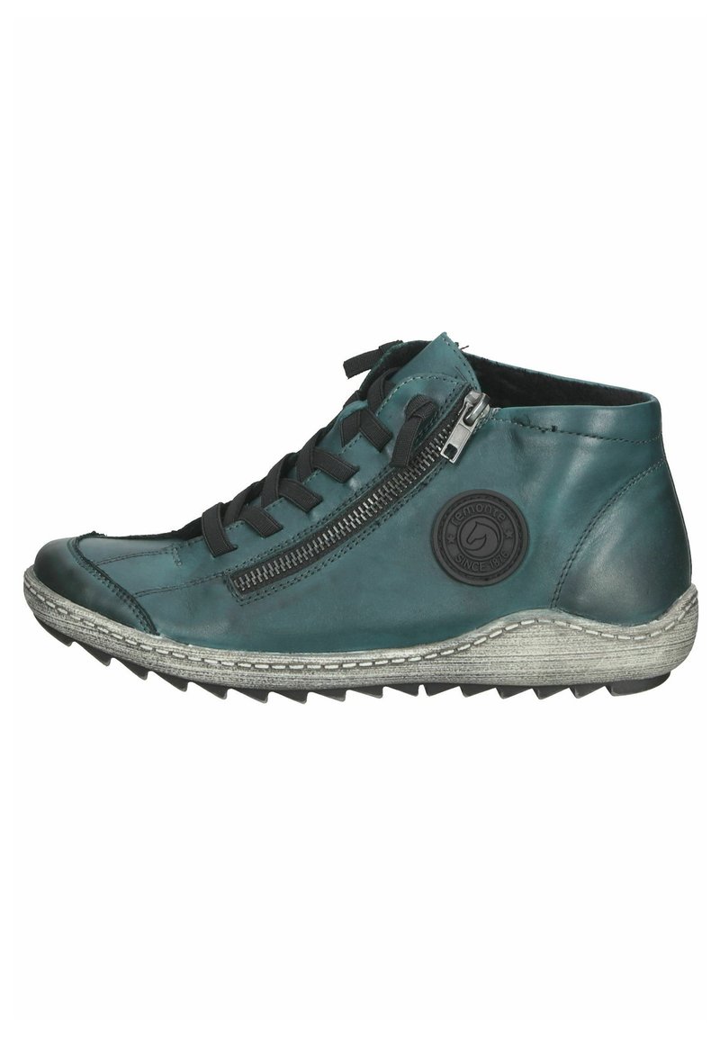 Botas de tobillo de piel verde azulado con cordones negros, cremallera lateral, suela texturizada gris y parche de logo redondo. Presentan un diseño aerodinámico y deportivo.