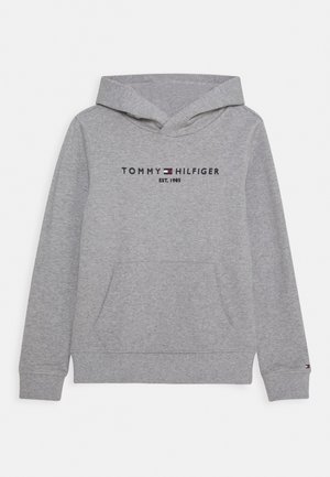 Jasnoszara bluza z kapturem i kieszenią z przodu, z haftowanym logo "Tommy Hilfiger Est. 1985" w kolorach czarnym, białym i czerwonym na piersi.