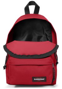 Zaino in tessuto rosso con spallacci regolabili, coperchio superiore e tasca frontale. Interno foderato; superficie testurizzata con dettagli neri.