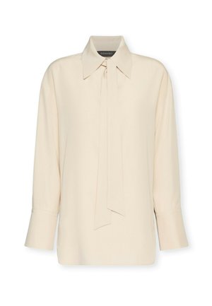 Kremowa bluzka z długim rękawem, z ostrym kołnierzem i wiązaniem z przodu przy szyi, z mankietami na guziki i luźnym krojem.