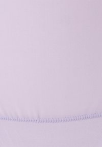 Detalhe de um tecido lilás claro com textura horizontal visível e uma linha de costura espaçada uniformemente perto da parte inferior.