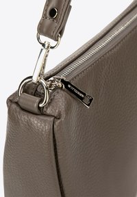 Szara skórzana torebka z zamkiem błyskawicznym, srebrnymi dodatkami i teksturowaną powierzchnią. Zawiera odpinany pasek z metalowym uchwytem.