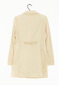 Beige pitkähihaisen takki, kevyt materiaali, jossa on kaulus, selkäpleatit ja kaksi näkyvää nappia vyötäröllä suljettuna.