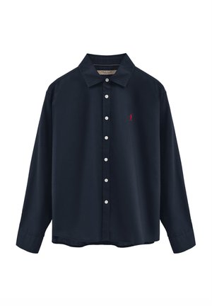 Chemise bleu marine à manches longues avec boutons blancs et une petite figure rouge brodée sur le côté gauche de la poitrine.