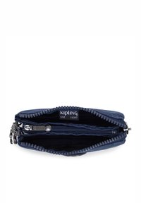 Portafoglio Kipling blu navy con chiusura a zip, dotato di doppio scomparto e etichetta con logo. Tessuto testurizzato e dettagli in metallo sono visibili.
