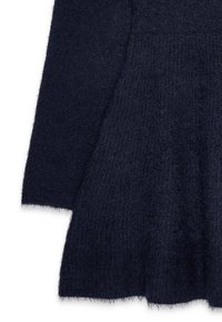 Granatowy, teksturowany sweter z falbaniastym dołem. Miękki, puszysty materiał nadaje ciepły wygląd. Długie rękawy z surowymi brzegami.