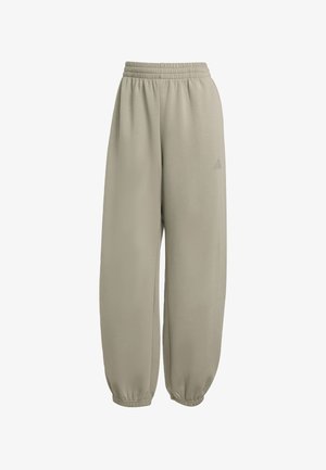 Jogging leggeri color beige chiaro realizzati in tessuto morbido. Presentano una vita elastica, caviglie strette e un design minimalista con un piccolo logo.