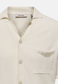 Weißes, strukturiertes Kurzarmhemd mit einem Eingriffkragen, Brusttasche und hellen Knöpfen, etikettiert mit "ONLY & SONS."